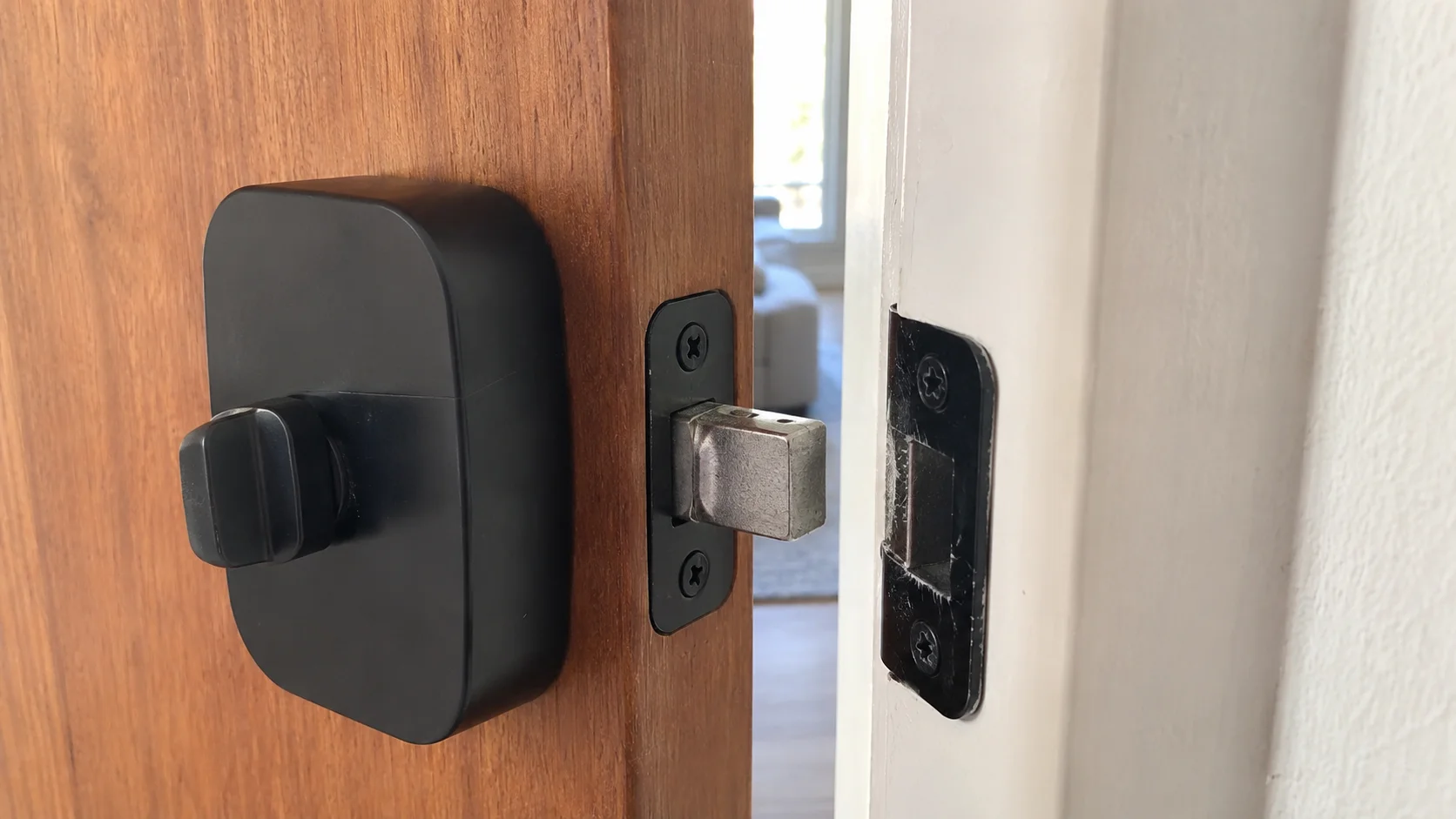 Smart Lock Deadbolt and Strike Plate Alignment Smart lock deadbolt positioned beside the strike plate on an open wooden door